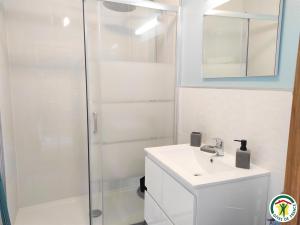 a white bathroom with a sink and a shower at Le gite des ecuries de marquecy in Évricourt +16 photos