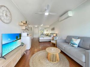 a living room with a couch and a tv at Blue on Blue Studio Room 1222 in Nelly Bay +12 photos