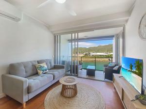 a living room with a couch and a large window at Blue on Blue Studio Room 1222 in Nelly Bay
