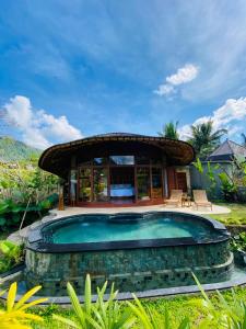 a swimming pool in front of a house at Abian Ayu Villa in Sidemen