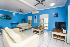 a living room with blue walls and white furniture at Azure on Geoffrey Bay in Arcadia +12 photos