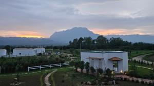 a building in a field with a mountain in the background at Doi Luang Vista Homestay in Ban Mae To +17 photos