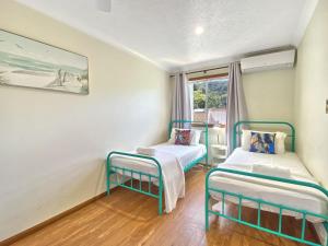 a room with two beds and a window at Island Magic Townhouse 5 in Arcadia