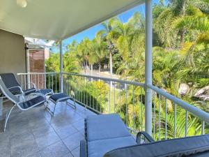 a balcony with chairs and palm trees and a view at Island Magic Townhouse 5 in Arcadia +8 photos