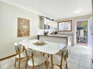 a kitchen and dining room with a white table and chairs at Island Magic Townhouse 5 in Arcadia