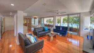 a living room with couches and chairs and a table at Maggies Beachfront Apartment 10 in Horseshoe Bay