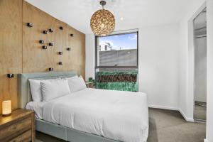 a bedroom with a white bed and a window at Stylish 2-Bed Apartment by 888 Collins in Melbourne +13 photos