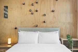 a bedroom with a white bed and a wooden wall at Stylish 2-Bed Apartment by 888 Collins in Melbourne
