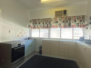 a kitchen with a sink and a stove top oven at Whitehaven 2 in Picnic Bay