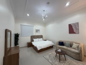a living room with a bed and a couch at شادن للوحدات السكنية in Qufār +3 photos
