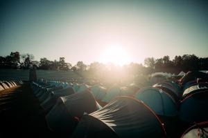 a group of tents in a field with the sun shining at Munich Oktoberfest Village Breakfast included by Yes-Trips! in Munich