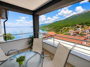 a balcony with a table and chairs and a view of the water at Apartments Marko in Ohrid