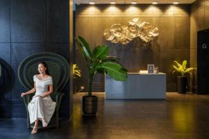 a woman sitting in a chair in a lobby at Hyatt Place Bangkok Sukhumvit 24 in Bangkok