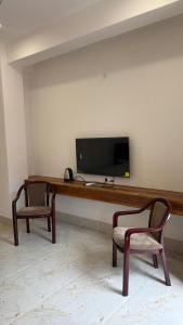 two chairs sitting in front of a desk with a television at Vortex Suites in Guwahati +28 photos