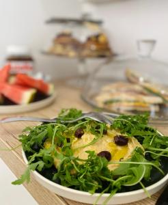 a plate of food with a salad on a table at La Locanda Chic B&B in Grosseto +26 photos