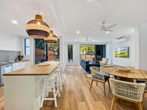 a kitchen and living room with a table and chairs at Picnic Point in Picnic Bay