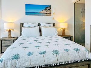 a bedroom with a bed with two lamps at 1 Bright Point Apartment 1407 in Nelly Bay +21 photos
