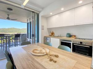a kitchen and dining room with a table and chairs at 1 Bright Point Apartment 1407 in Nelly Bay
