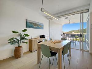 a kitchen and dining room with a wooden table and chairs at 1 Bright Point Apartment 1407 in Nelly Bay