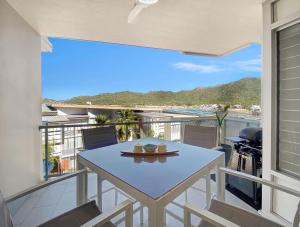 a table and chairs on a balcony with a view at 1 Bright Point Apartment 1407 in Nelly Bay