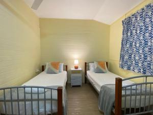 a room with two beds and a lamp on a table at The Captains Manor On Cook 5 in Arcadia
