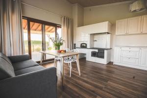 a living room with a table and a kitchen at Sodyba Pelėdų medus in Vainekoniai