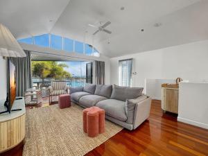 a living room with a couch and a television at Waters Edge Townhouse 4 in Nelly Bay +32 photos
