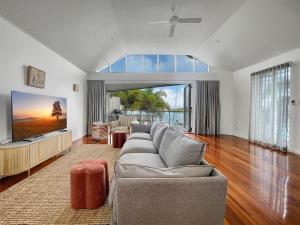 a living room with a couch and a tv at Waters Edge Townhouse 4 in Nelly Bay
