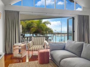 a living room with a couch and a view of the water at Waters Edge Townhouse 4 in Nelly Bay