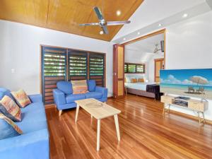 a living room with a blue couch and a tv at Pure Magnetic Villa 4 in Nelly Bay