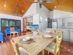 a dining room and living room with a table and chairs at Pure Magnetic Villa 4 in Nelly Bay