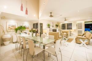 a dining room with a glass table and chairs at Eeast on Picnic in Picnic Bay