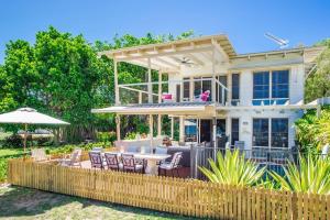 a house with a patio with a table and chairs at Eeast on Picnic in Picnic Bay