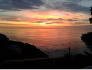 a sunset over a body of water with at La Terrasse 1-Vue Mer Panoramique & Piscine, BBQ in Begur