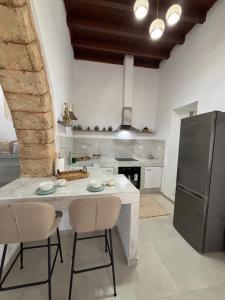 a kitchen with a table with chairs and a refrigerator at Bougainvillea in Asklipiḯon +14 photos