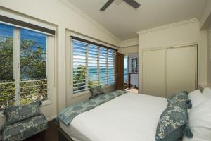 a bedroom with a bed and a large window at Driftwood in Picnic Bay