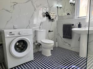 a bathroom with a washer and a toilet and a sink at 166, Rodolfu in Sliema +14 photos
