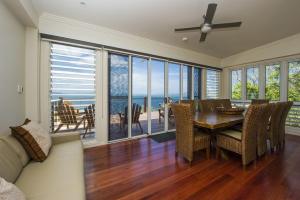 a dining room with a table and chairs and a couch at Driftwood in Picnic Bay