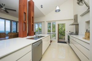 a kitchen with white counters and a large window at Driftwood in Picnic Bay