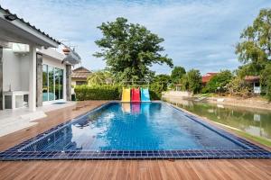 a swimming pool with a playground in the middle of a house at Shark House - Pool Villa RB13 in Ban Klam