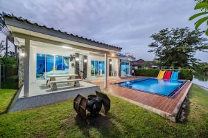 a backyard with a swimming pool and a house at Shark House - Pool Villa RB13 in Ban Klam