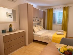 a small bedroom with a bed and a dresser at Apartments Marijan in Orebić