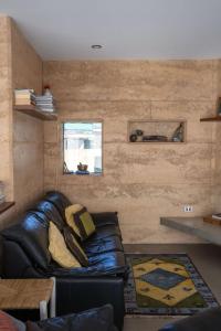 a living room with a leather couch and a window at The Well - Peterborough in Peterborough