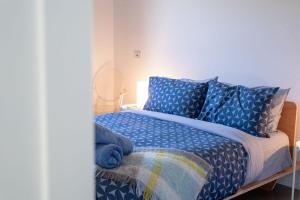 a bed with a blue comforter and blue pillows at The Well - Peterborough in Peterborough +34 photos