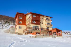 a large building on top of a snow covered slope at Pensiunea Daria in Fundata
