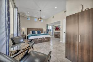 a bedroom with a bed and a desk and chairs at Ultimate Vacation: A Luxurious Oasis with a Pool! in Las Vegas +29 photos