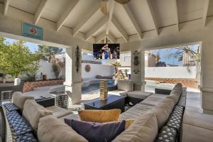 a living room with couches and a tv at Ultimate Vacation: A Luxurious Oasis with a Pool! in Las Vegas