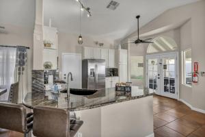 a kitchen with white cabinets and a marble counter top at Ultimate Vacation: A Luxurious Oasis with a Pool! in Las Vegas