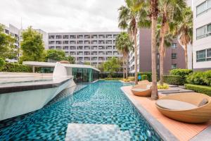 a swimming pool with two toilets and a building at Modern Studio Pool View, King bed, BTS Punnawithi in Bangkok