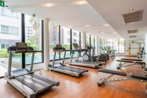 a gym with several treadmills and exercise bikes at Modern Studio Pool View, King bed, BTS Punnawithi in Bangkok